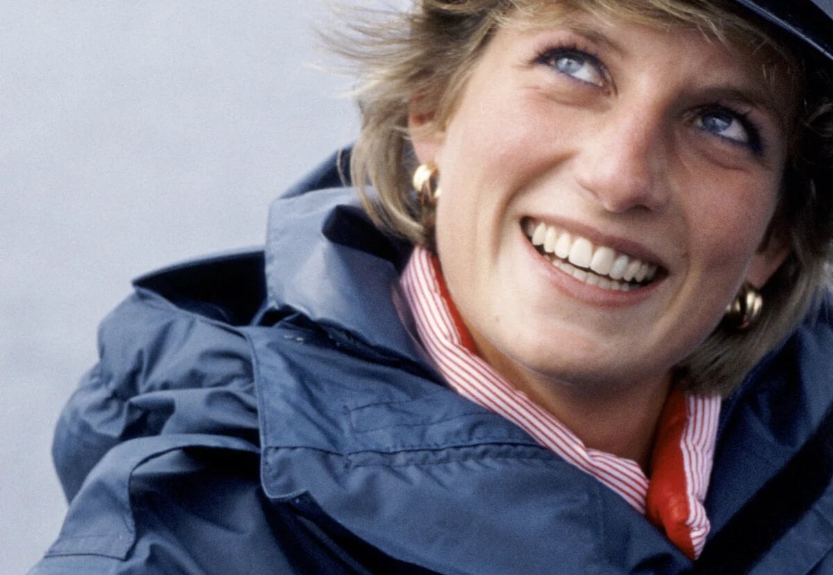 Princess Diana smiling and wearing a jacket