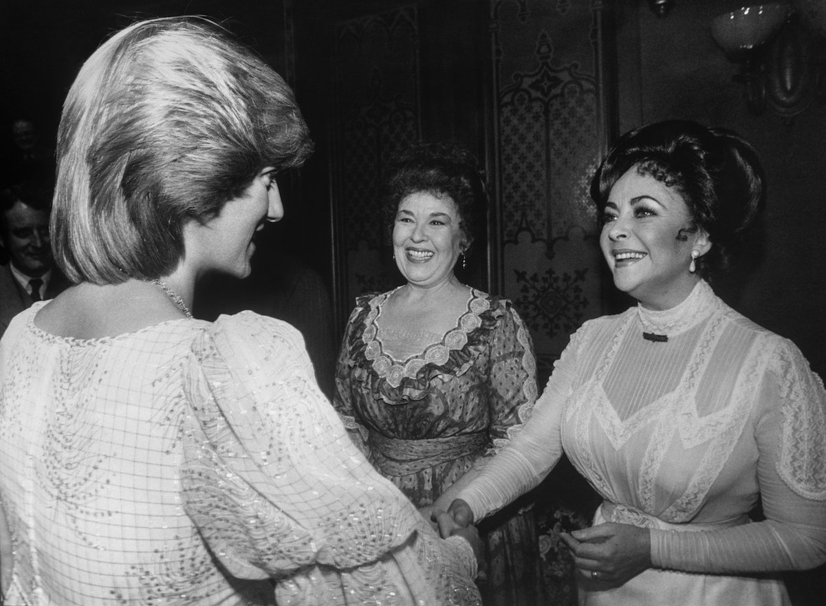 Elizabeth Taylor (right) shakes hands with Princess Diana