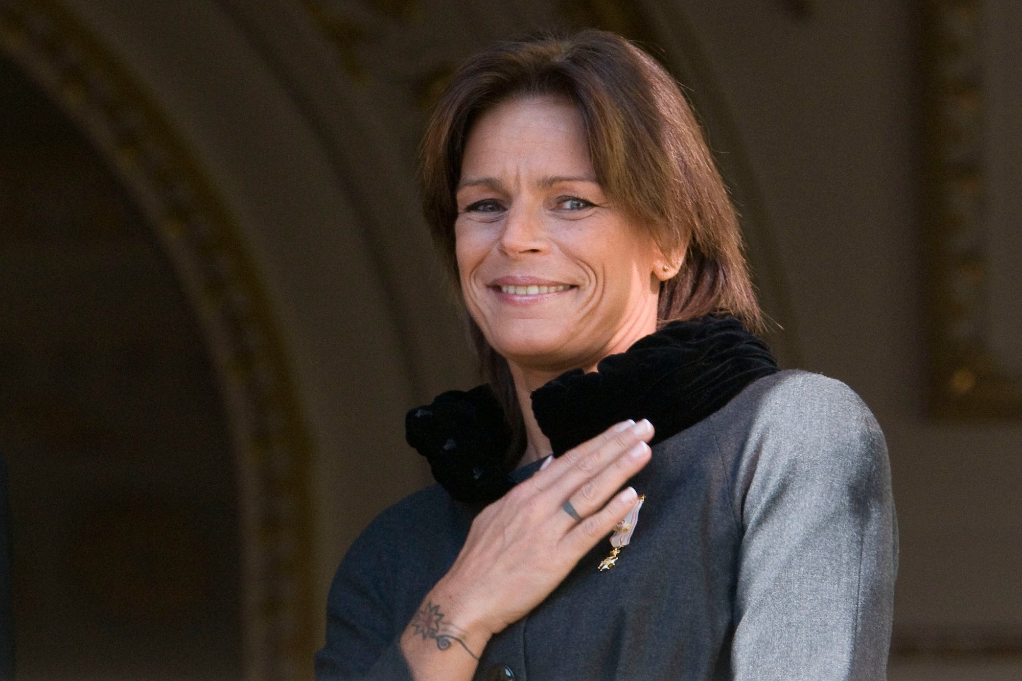 Princess Stephanie of Monaco, smiling, touching her shoulder