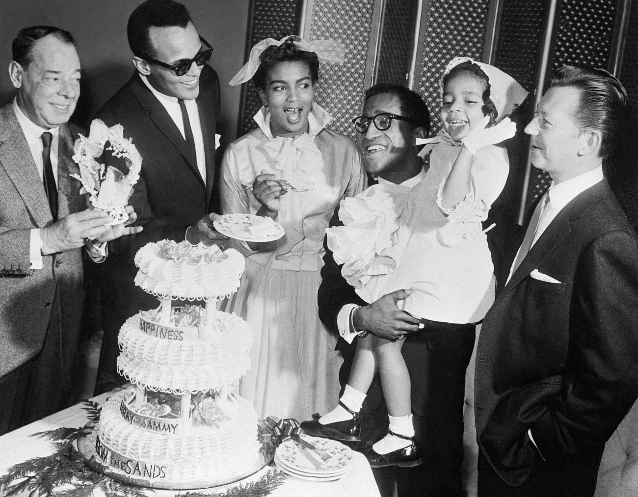 Sammy Davis Jr. on his wedding day with Loray White, holding his sister, Suzette, along with Harry Belafonte, Donald O'Connor, and Joe E. Lewis