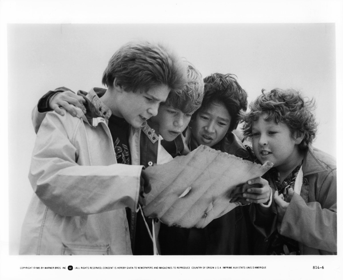 L to R: Corey Feldman, Sean Astin, Ke Huy Quan and Jeff Cohen reading a treasure map in a scene from the film 'Goonies', 1985.