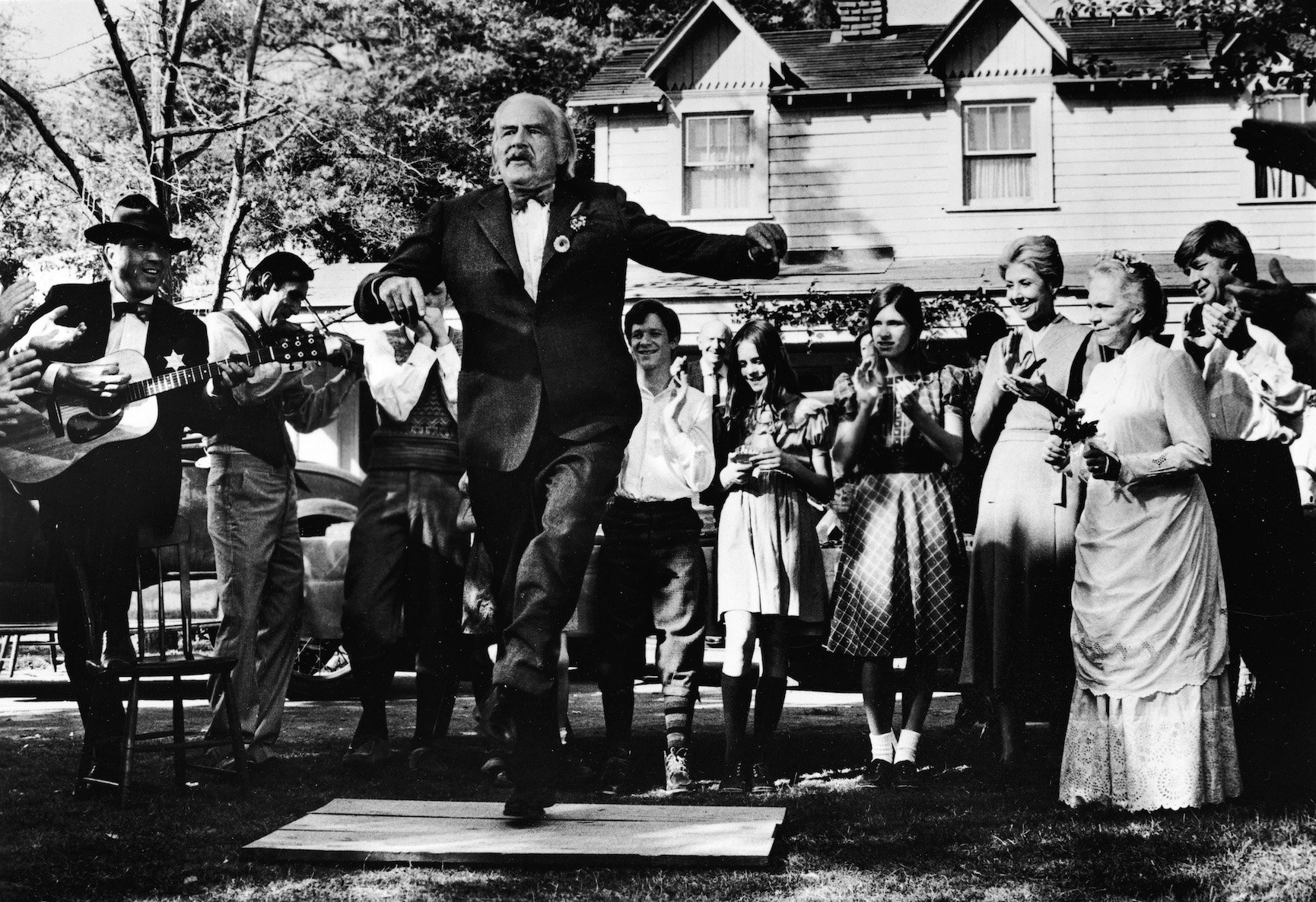 Actor Will Geer as Grandpa Walton dancing a jig in front of the Walton house on 'The Waltons'