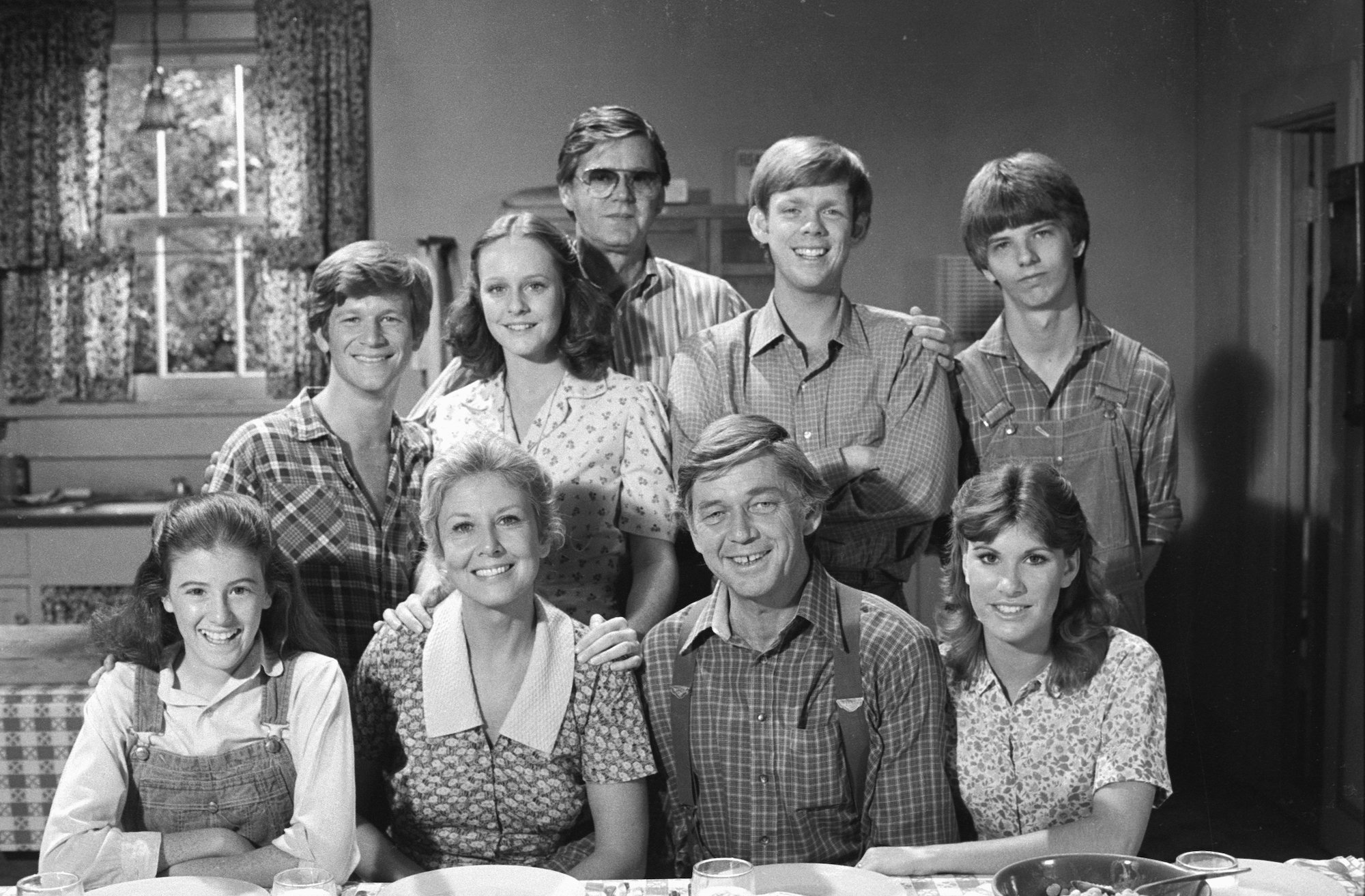 Top Row From Left: Eric Scott as Ben Walton, Mary McDonough as Erin Walton, executive producer Earl Hamner, Jon Walmsley as Jason Walton, David Harper as Jim-Bob Walton. Bottom line from left: Kami Cotler as Elizabeth Walton, Michael Learned as Olivia Walton, Ralph Waite as John Walton, Judy Norton as Mary Ellen Walton smiling, in black and white