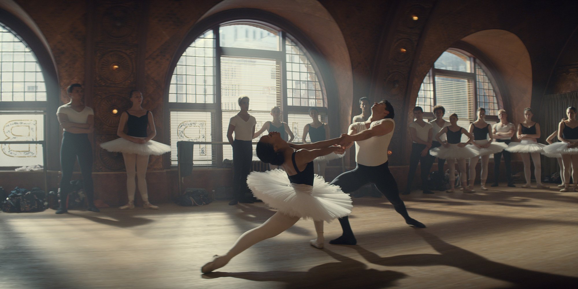 (L-R) A ballet dancer in a tutu dancing with a male dancer in a studio