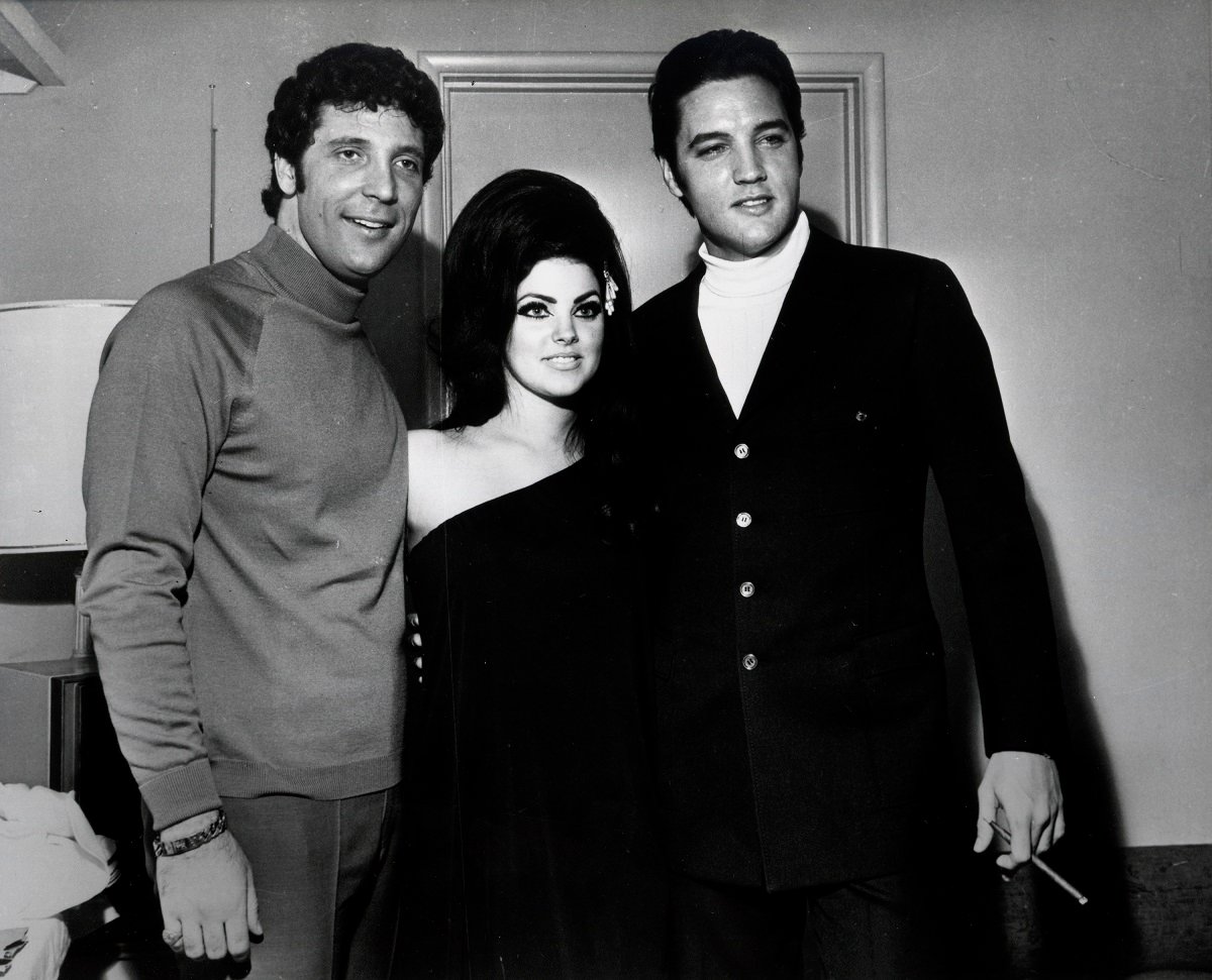 Tom Jones, Priscilla Presley, and Elvis Presley in front of a wall