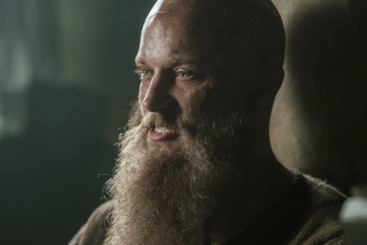 Travis Fimmel as Ragnar Lothbrok in 'Vikings' with a bald head and long beard.