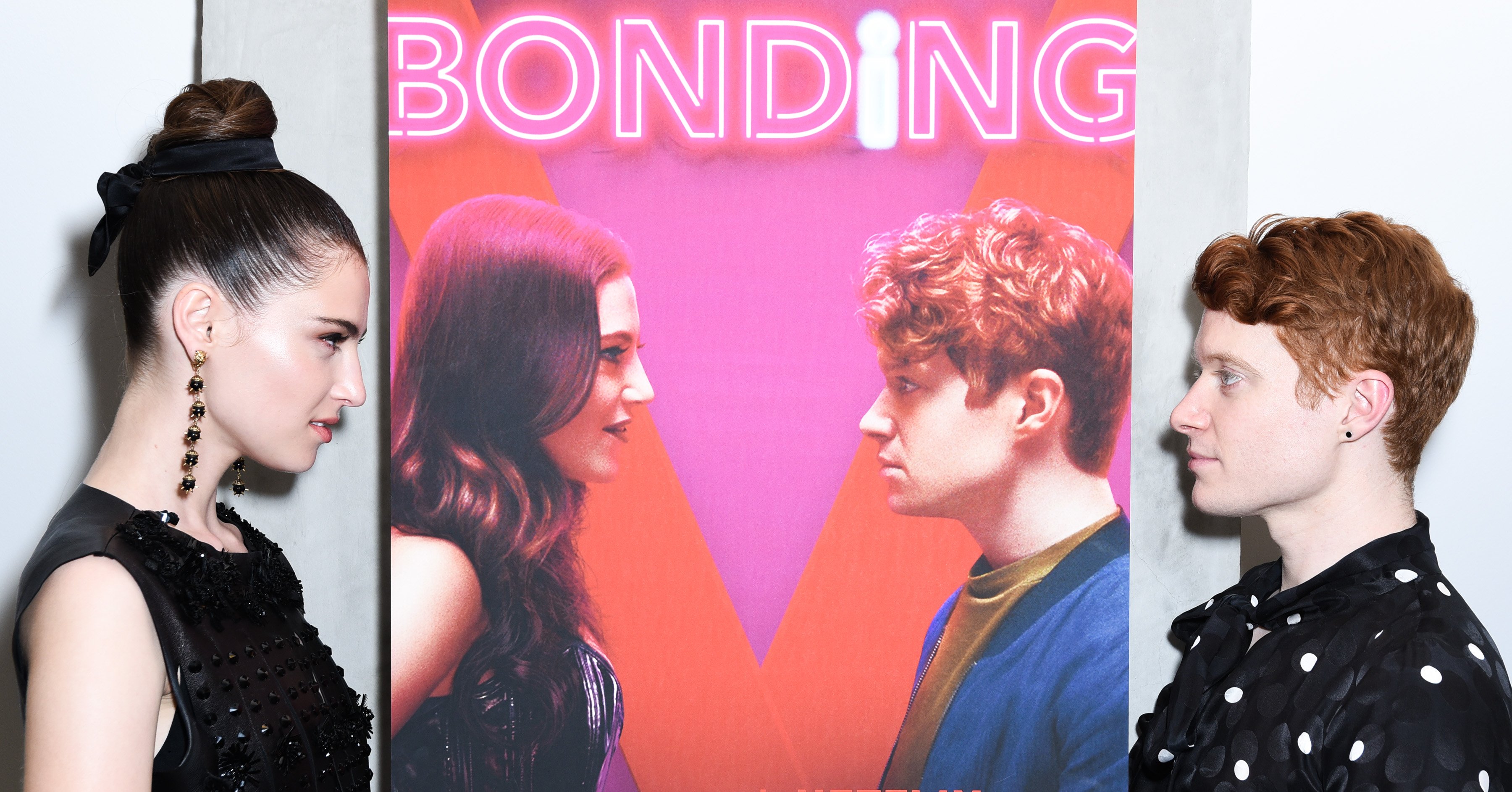 Zoe Levin and Brendan Scannel near a poster for Bonding