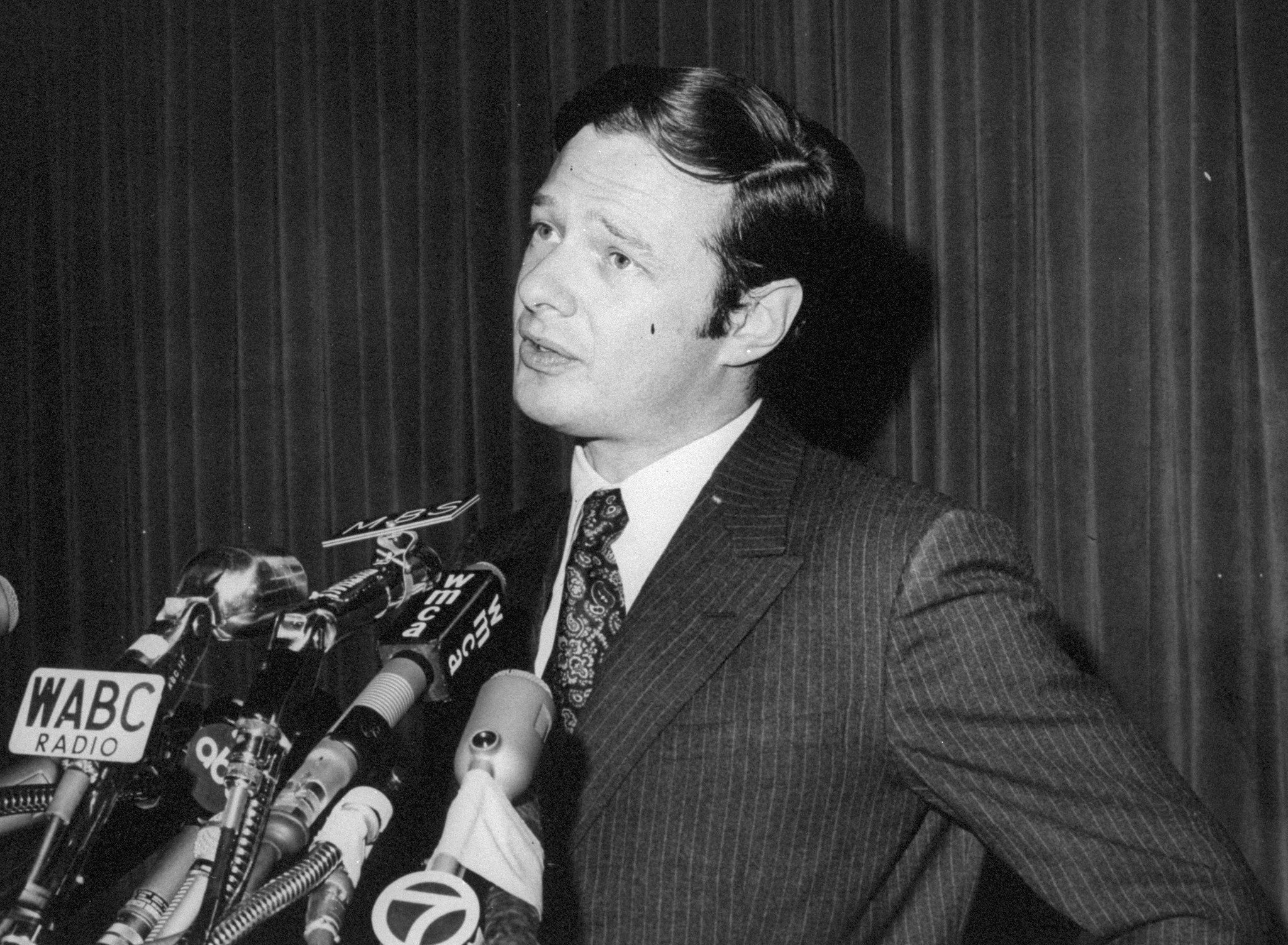 Brian Epstein surrounded by microphones