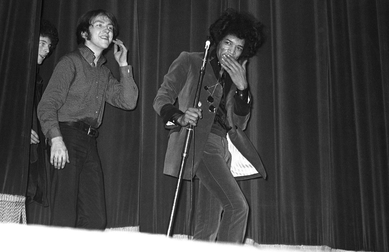 Jimi Hendrix stifles a laugh as he walks on stage