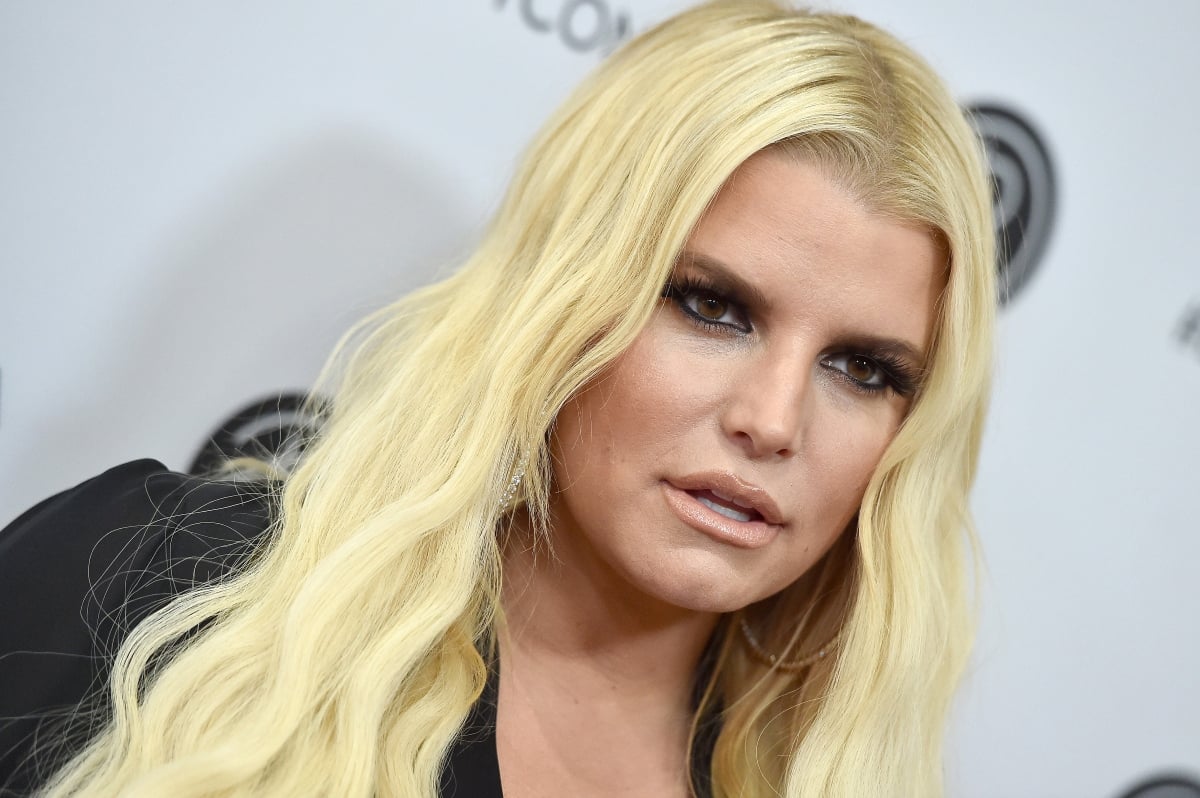 Closeup of Jessica Simpson looking on in front of a gray backdrop