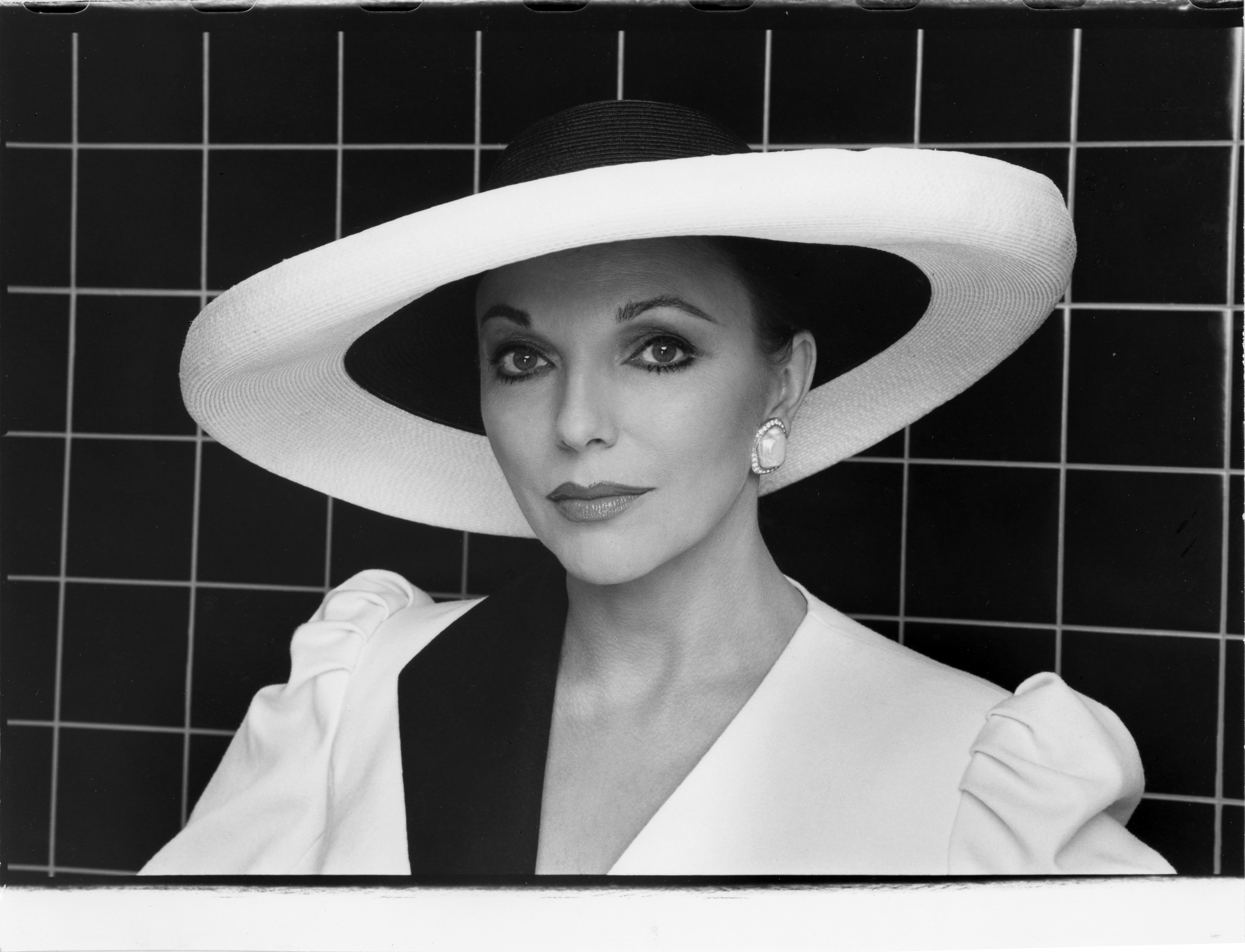 Joan Collins wearing a hat