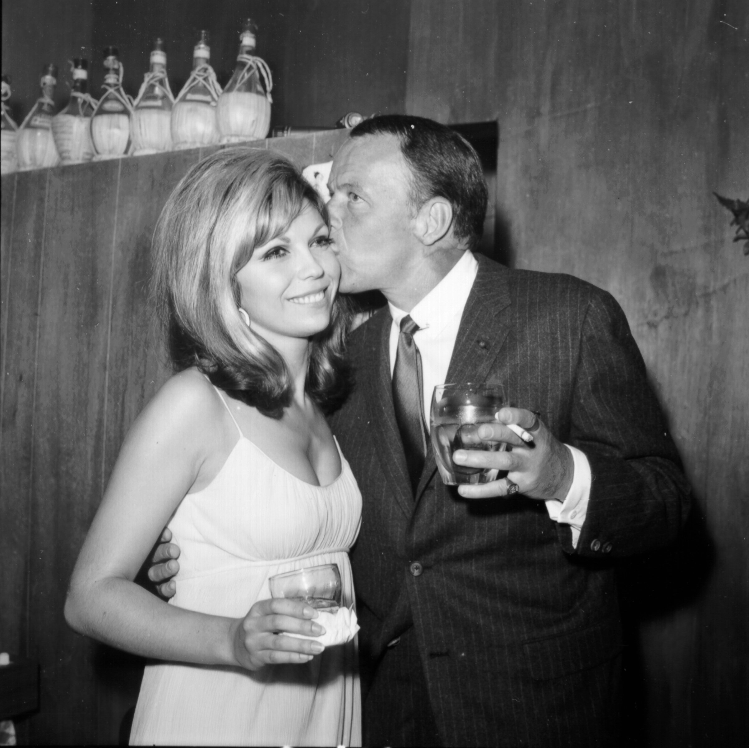Frank Sinatra and Nancy Sinatra near bottles
