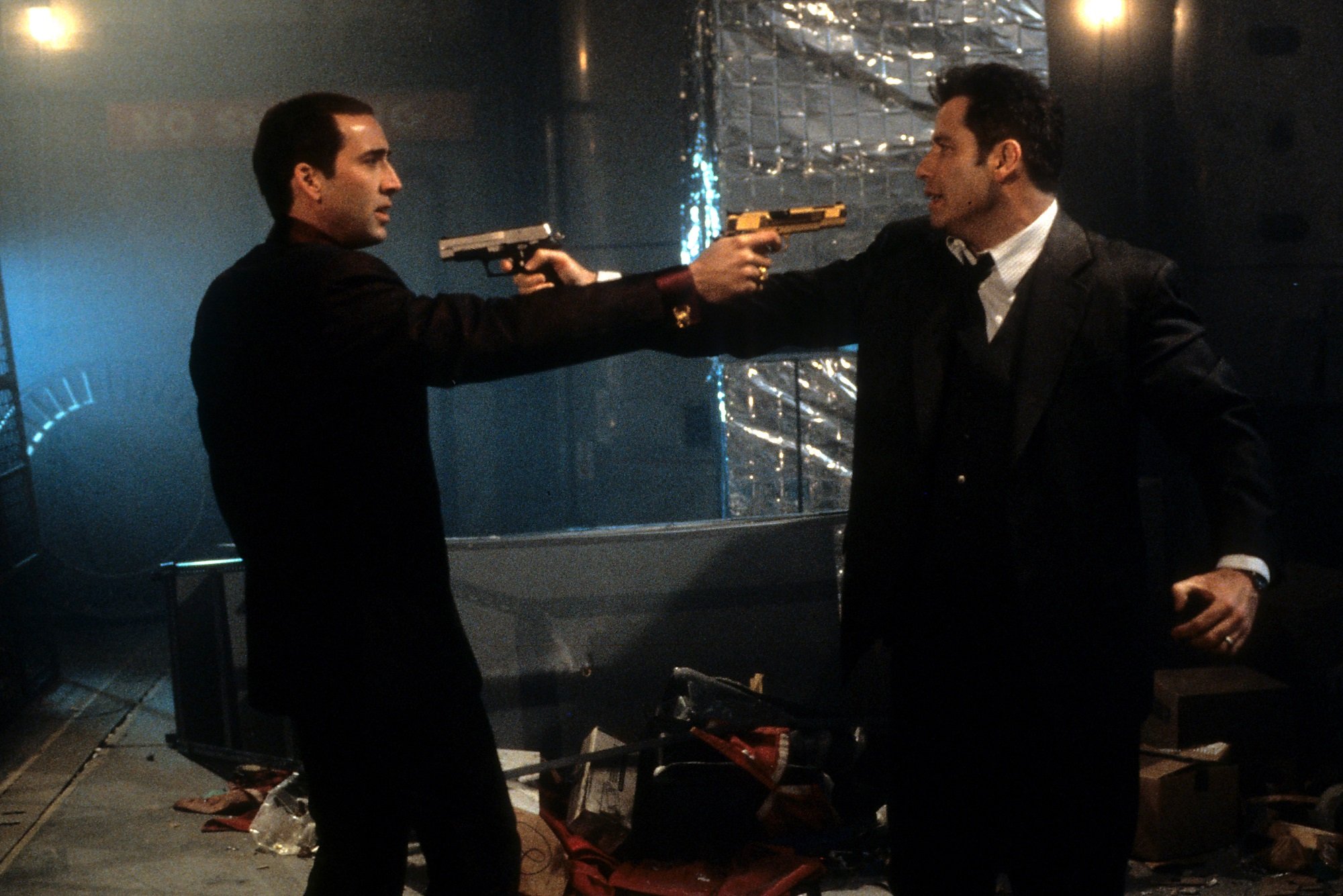 Face/Off stars Nicolas Cage and John Travolta point guns at each other