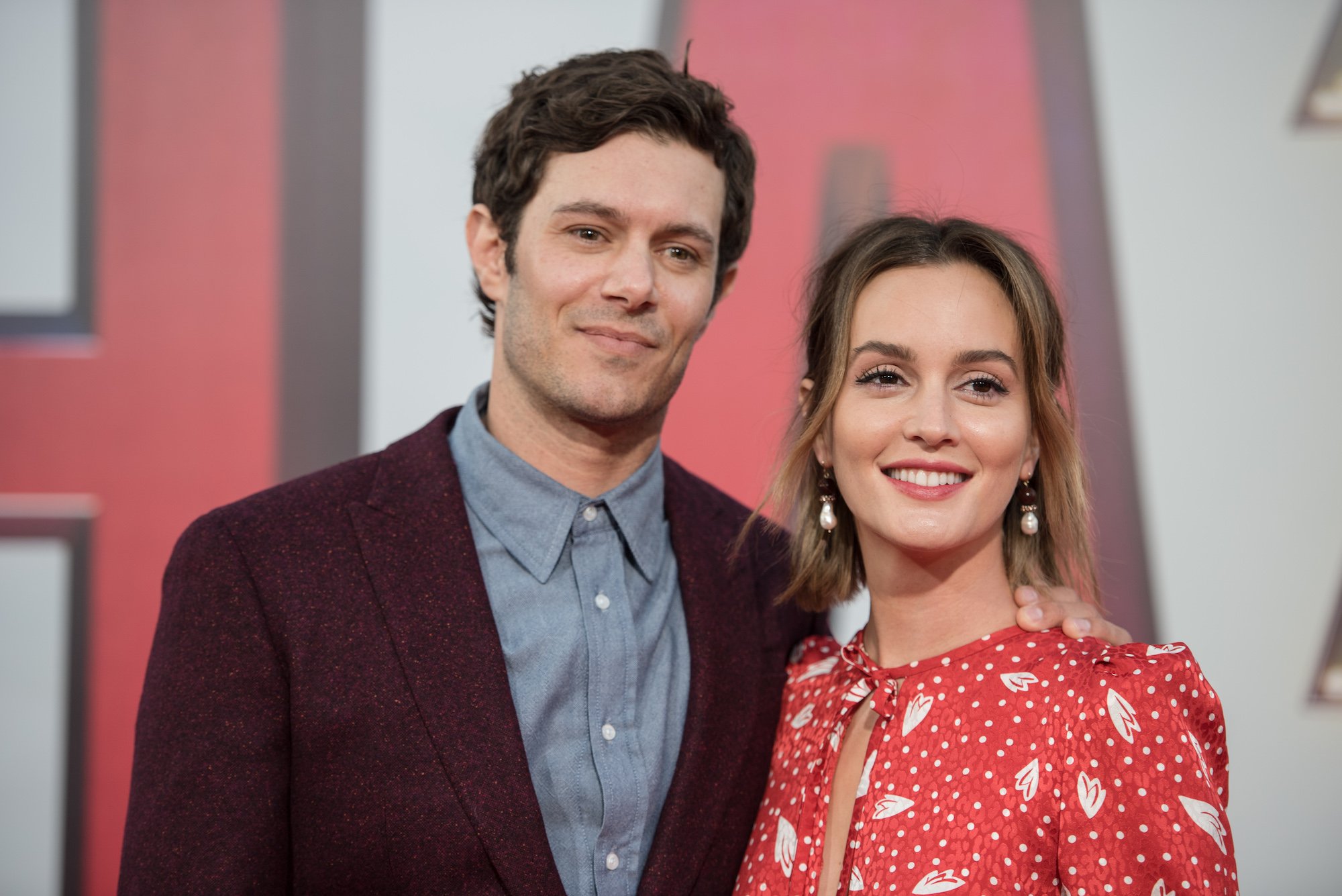 (L-R) Adam Brody and Leighton Meester smiling in front of a blurred background