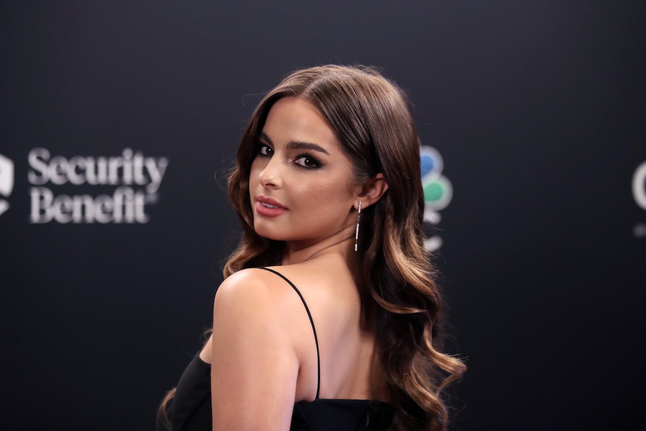 Addison Rae looking over shoulder in front of black background