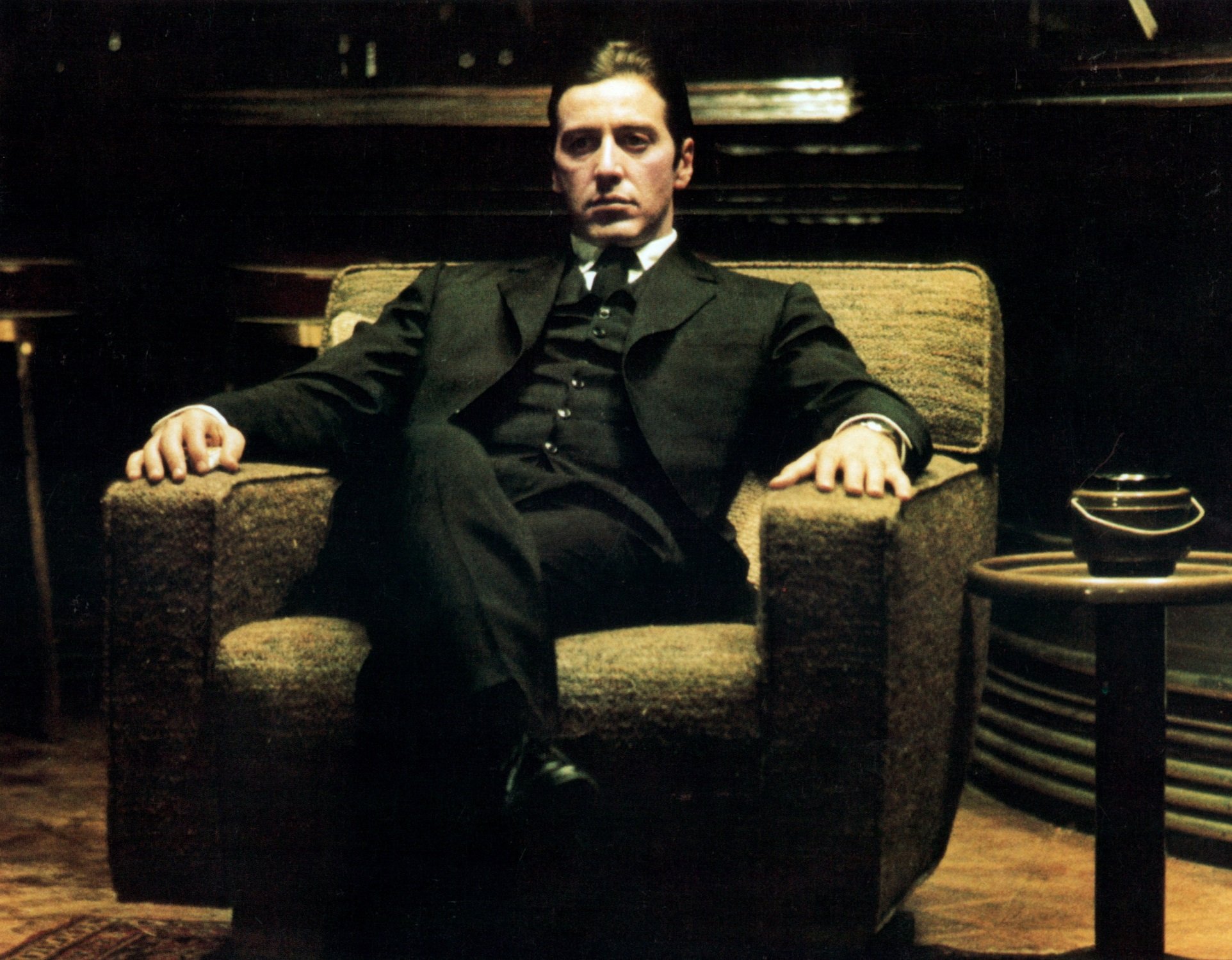 Al Pacino sits in a chair in a scene from the film 'The Godfather: Part II',
