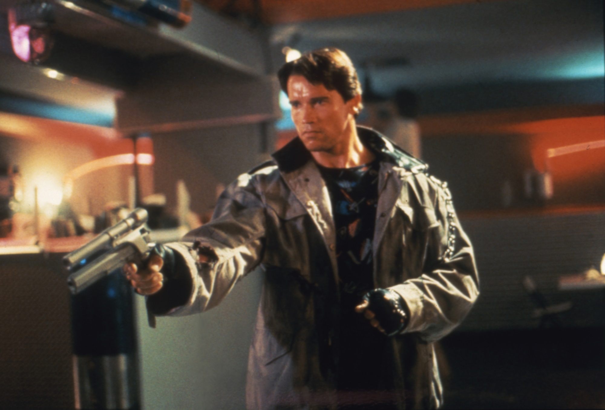Arnold Schwarzenegger as The Terminator aims at Sarah Connor