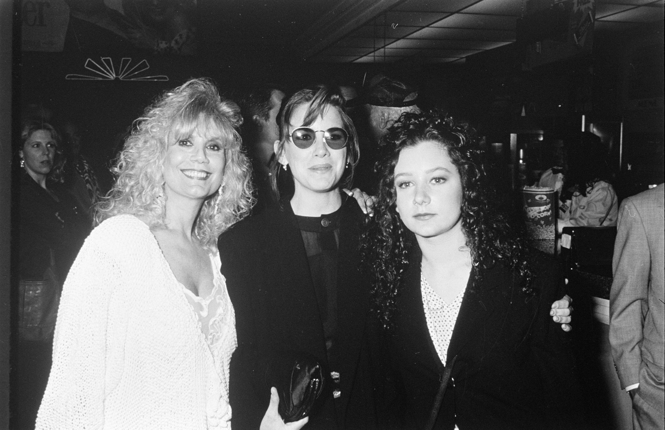 Barbara Crane (later Cowan), Melissa Gilbert, Sara Gilbert huddle together at an event, photographed in black and white. 