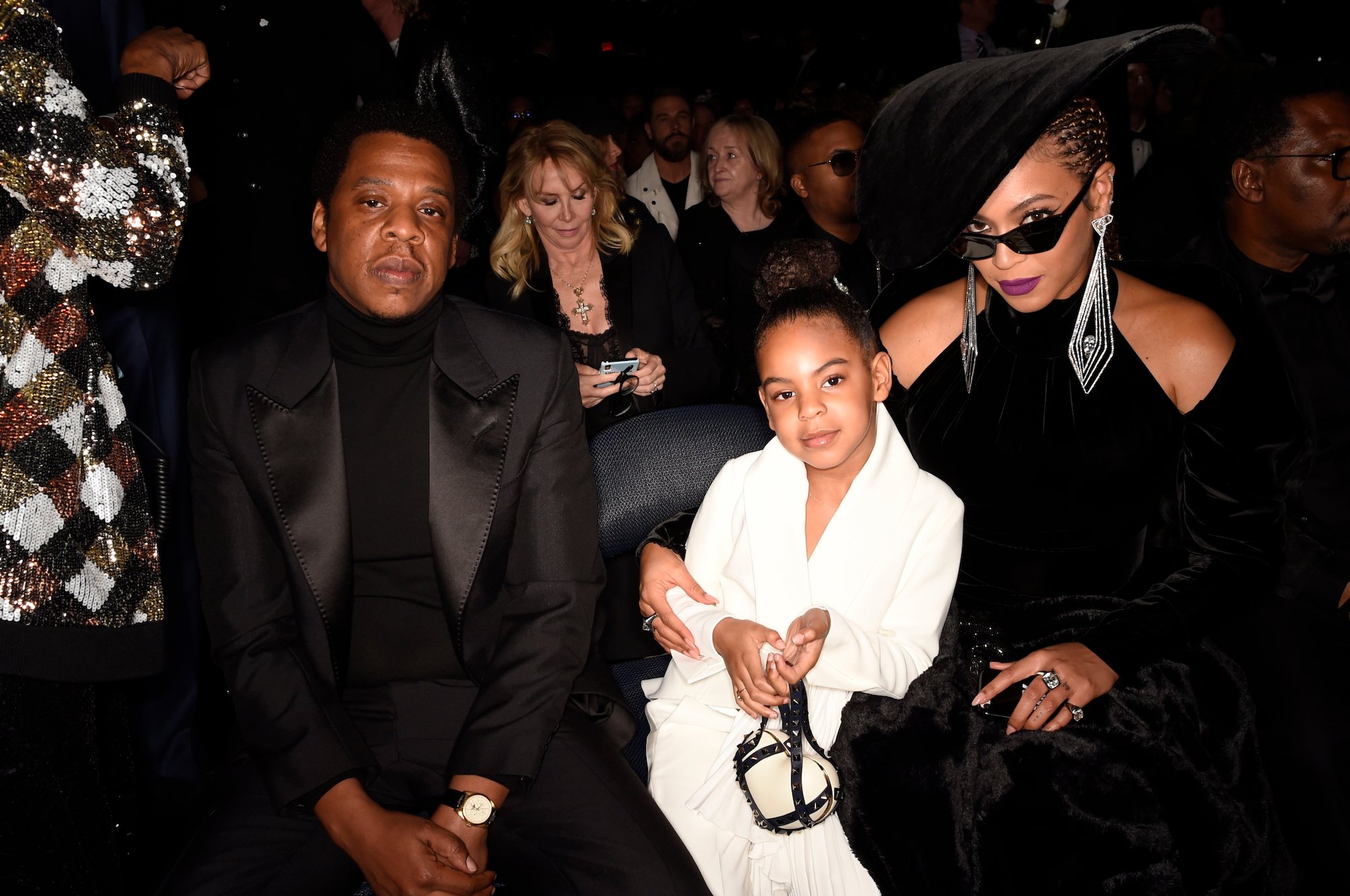 (L-R) Jay-Z, Blue Ivy, and Beyoncé looking at the camera, seated in a theater