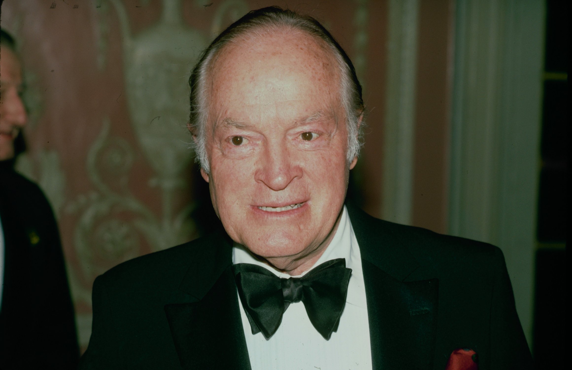 Bob Hope smiling looking to the right in front of a blurred background