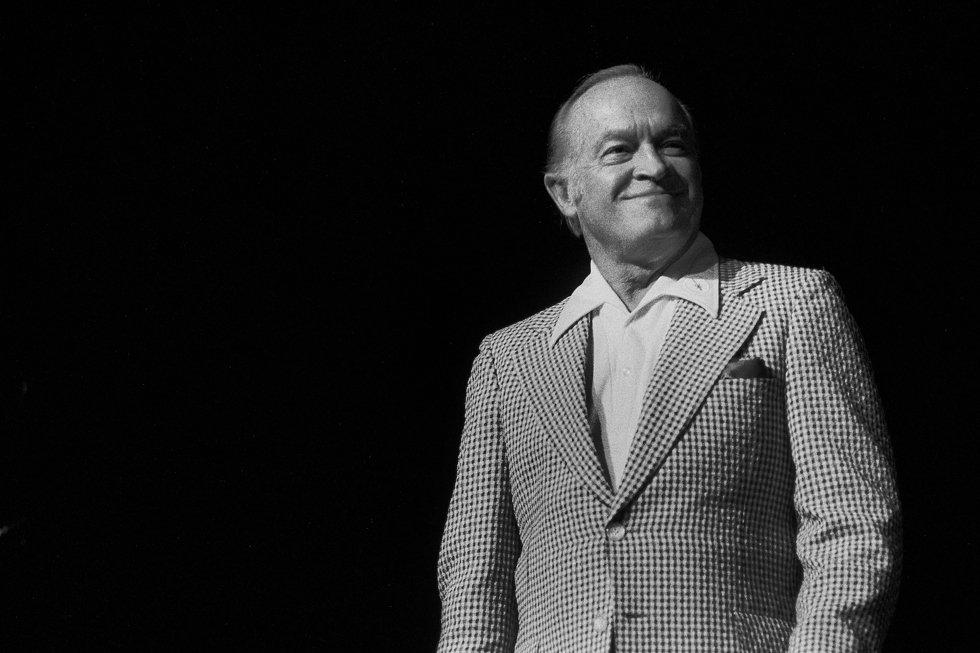 Bob Hope smiling in front of a black background