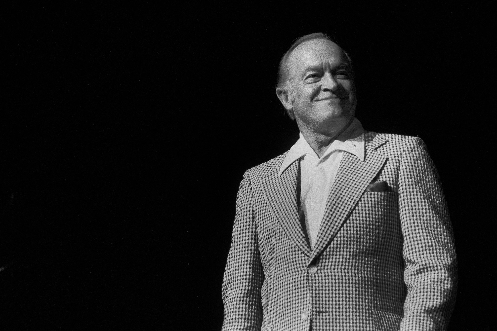 Bob Hope smiling in front of a black background