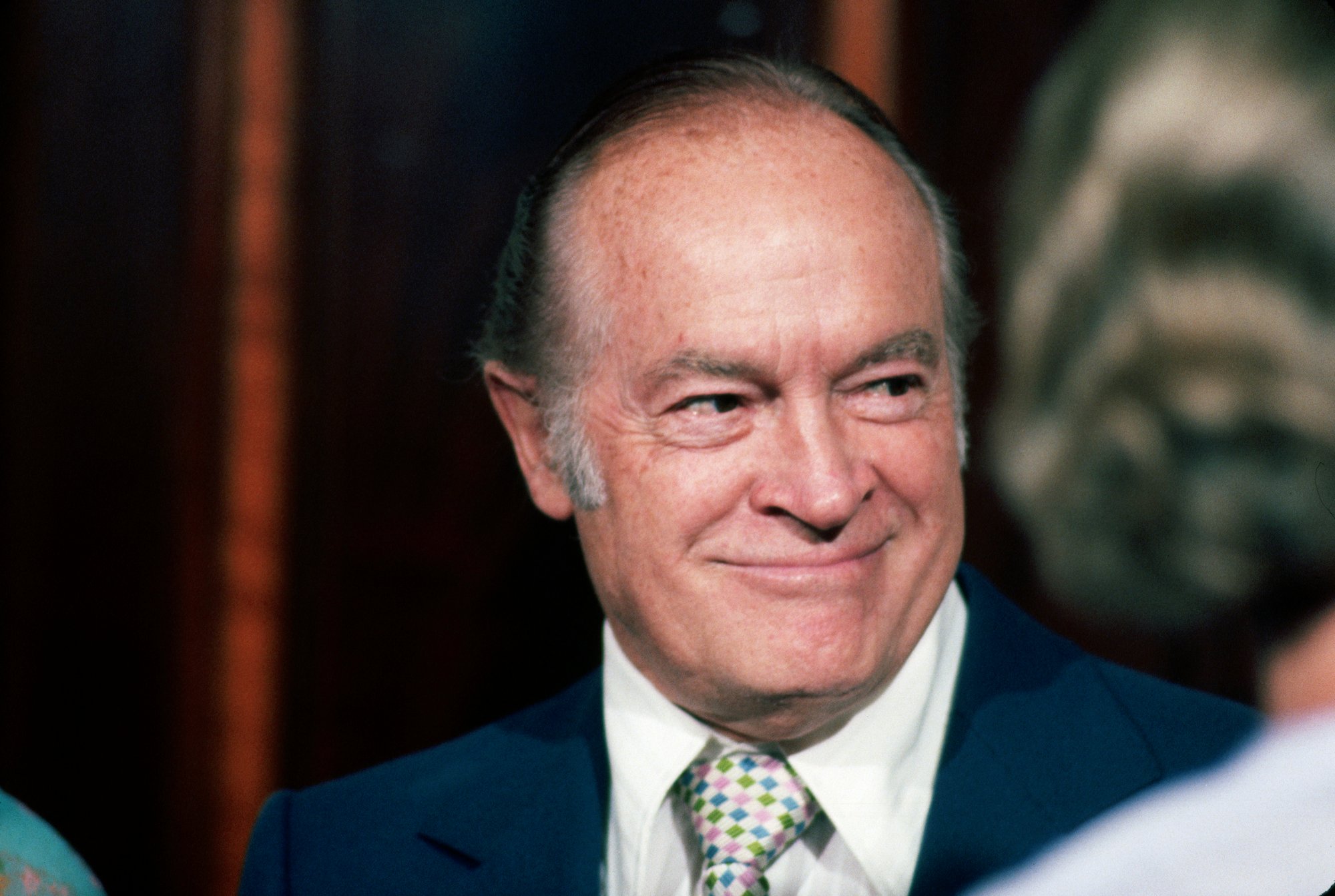 Bob Hope smiling looking to the right in front of a blurred background