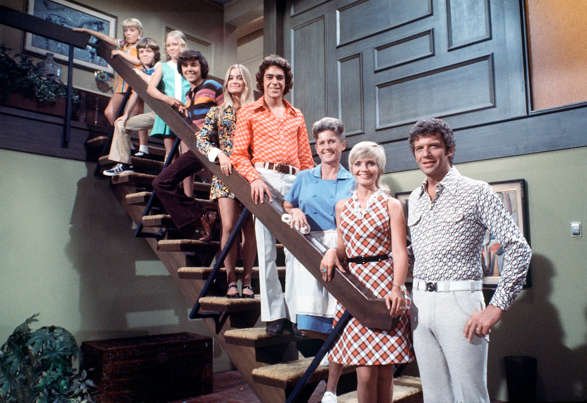 'The Brady Bunch' cast stands on the staircase of their living room set
