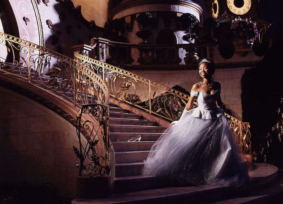 Brandy Norwood in her Cinderella gown on a gilded staircase with a glass slipper behind her in 'Rodgers and Hammerstein's Cinderella' on ABC, 1997 | Disney