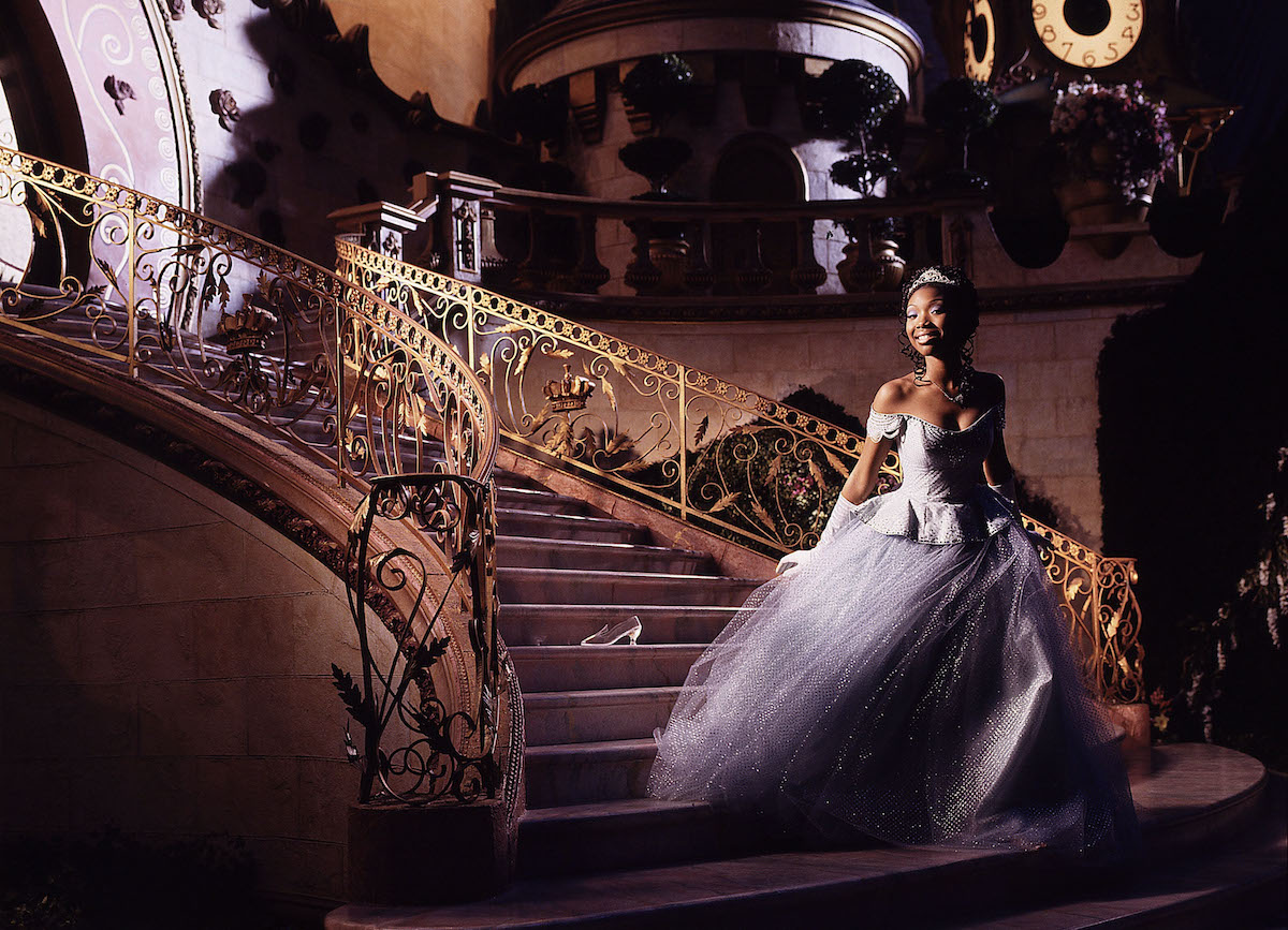 Brandy Norwood in her Cinderella gown on a gilded staircase with a glass slipper behind her in 'Rodgers and Hammerstein's Cinderella' on ABC, 1997 | Disney