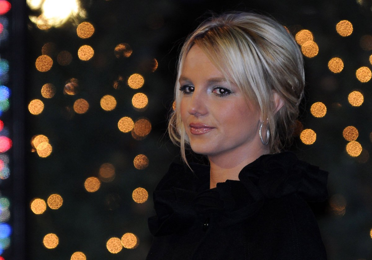 Britney Spears headshot with her wearing black and her hair tied up with bangs framing her face.