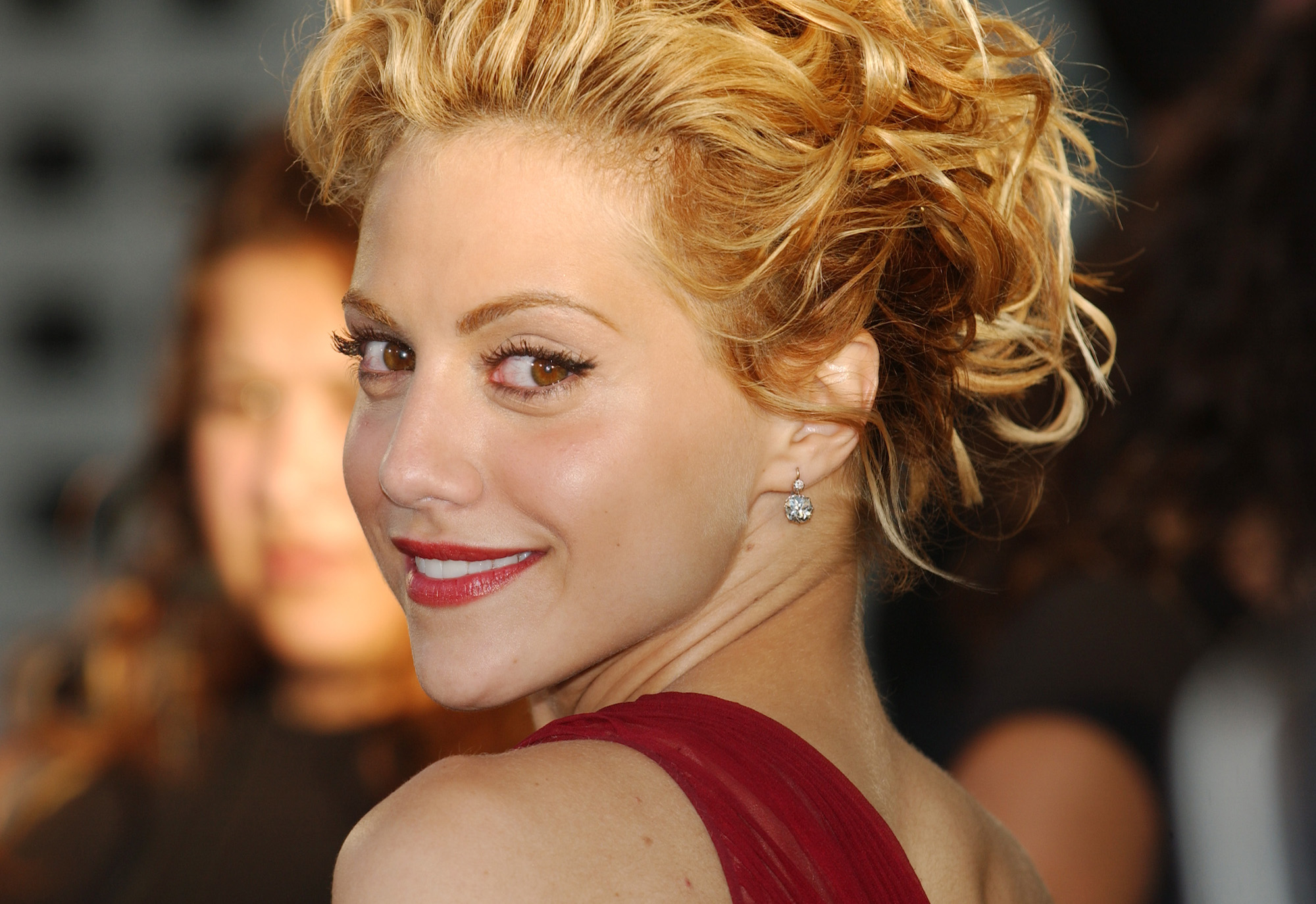 Brittany Murphy smiling in front of a blurred background