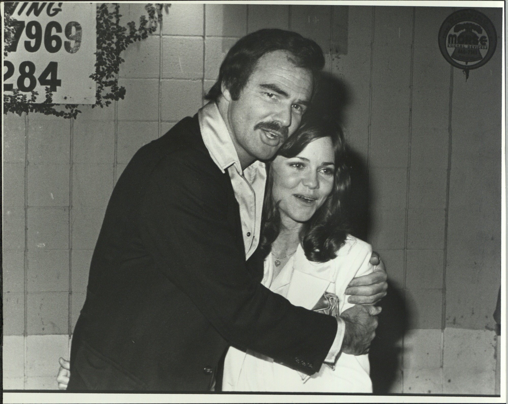 (L-R) Burt Reynolds and Sally Field embracing, in black and white