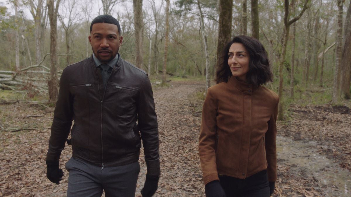 Charles Michael Davis as Special Agent Quentin Carter and Necar Zadegan as Special Agent Hannah Khoury walk in the woods