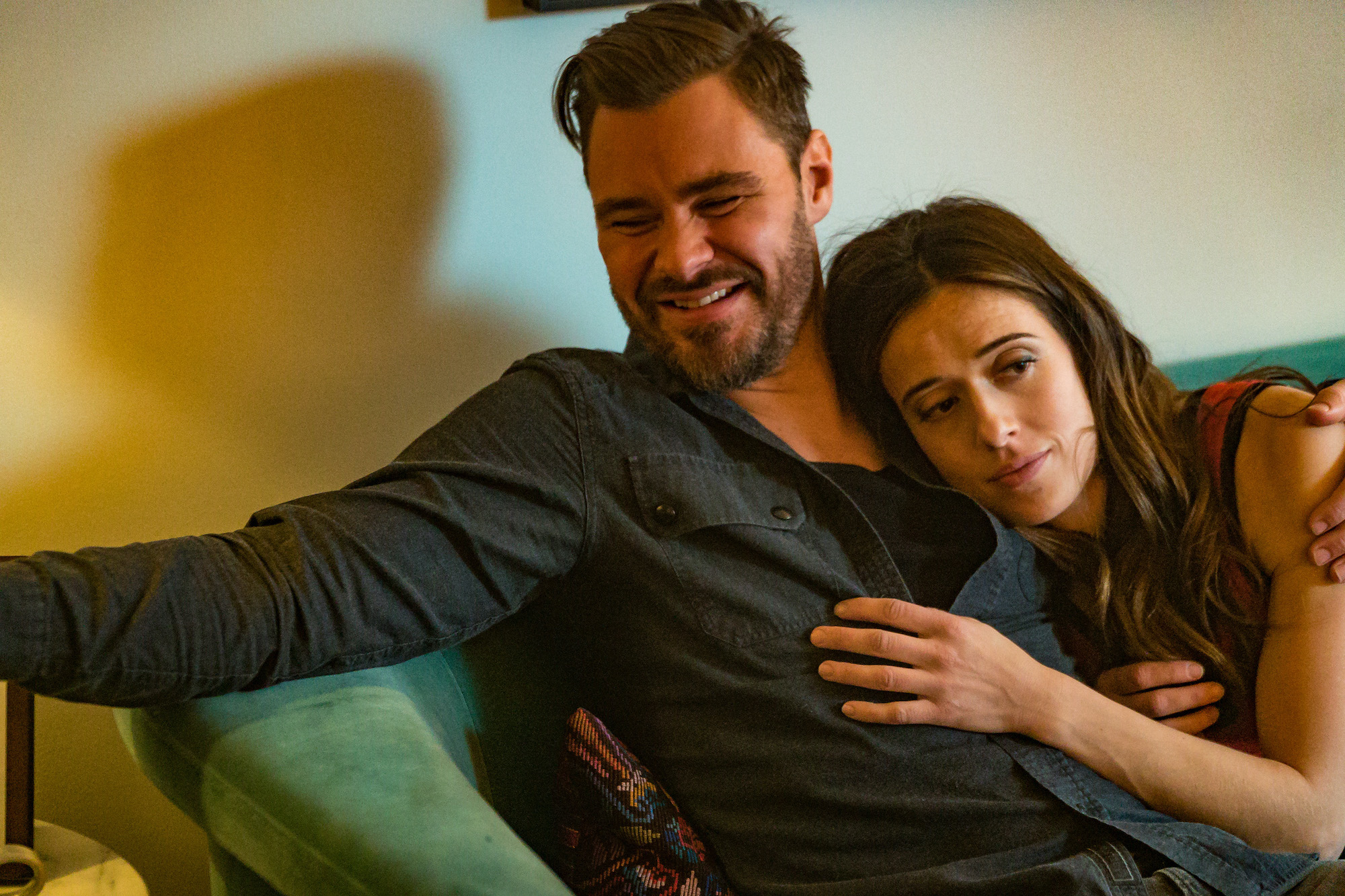 (L-R) Patrick John Flueger as Adam Ruzek laughing on the couch with Marina Squerciati as Kim Burgess leaning on his chest
