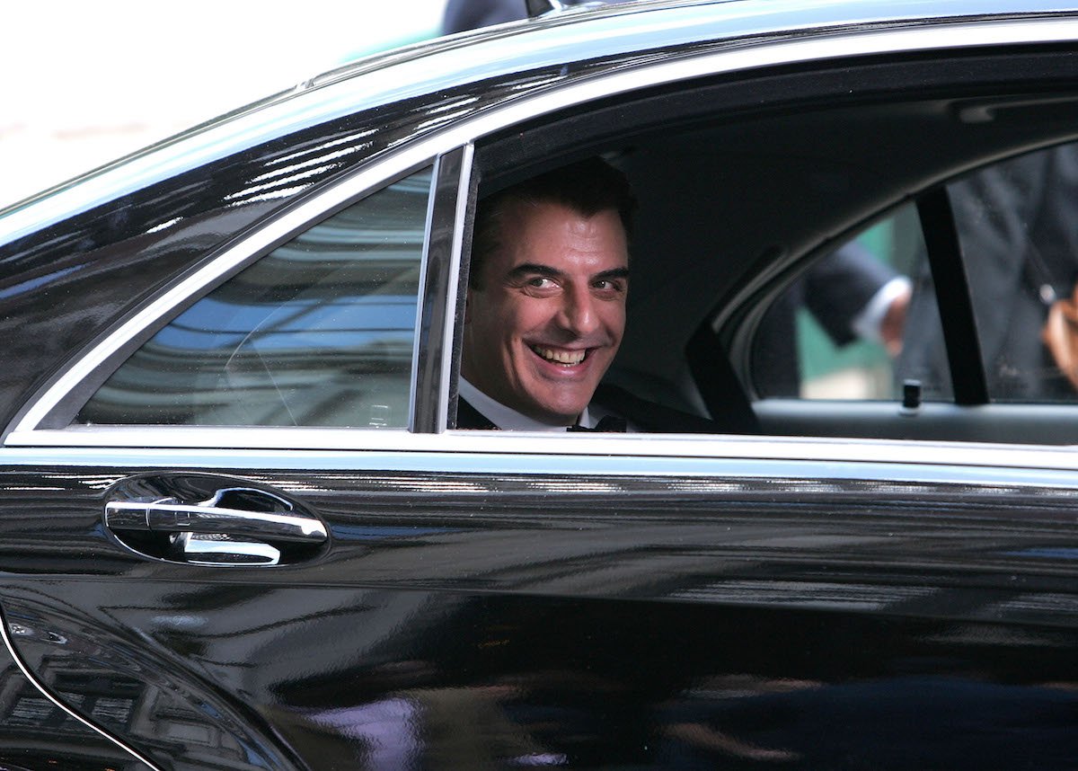 Chris Noth smiles at the camera from the back of a car during the filming of 'Sex and the City: The Movie' in New York City 