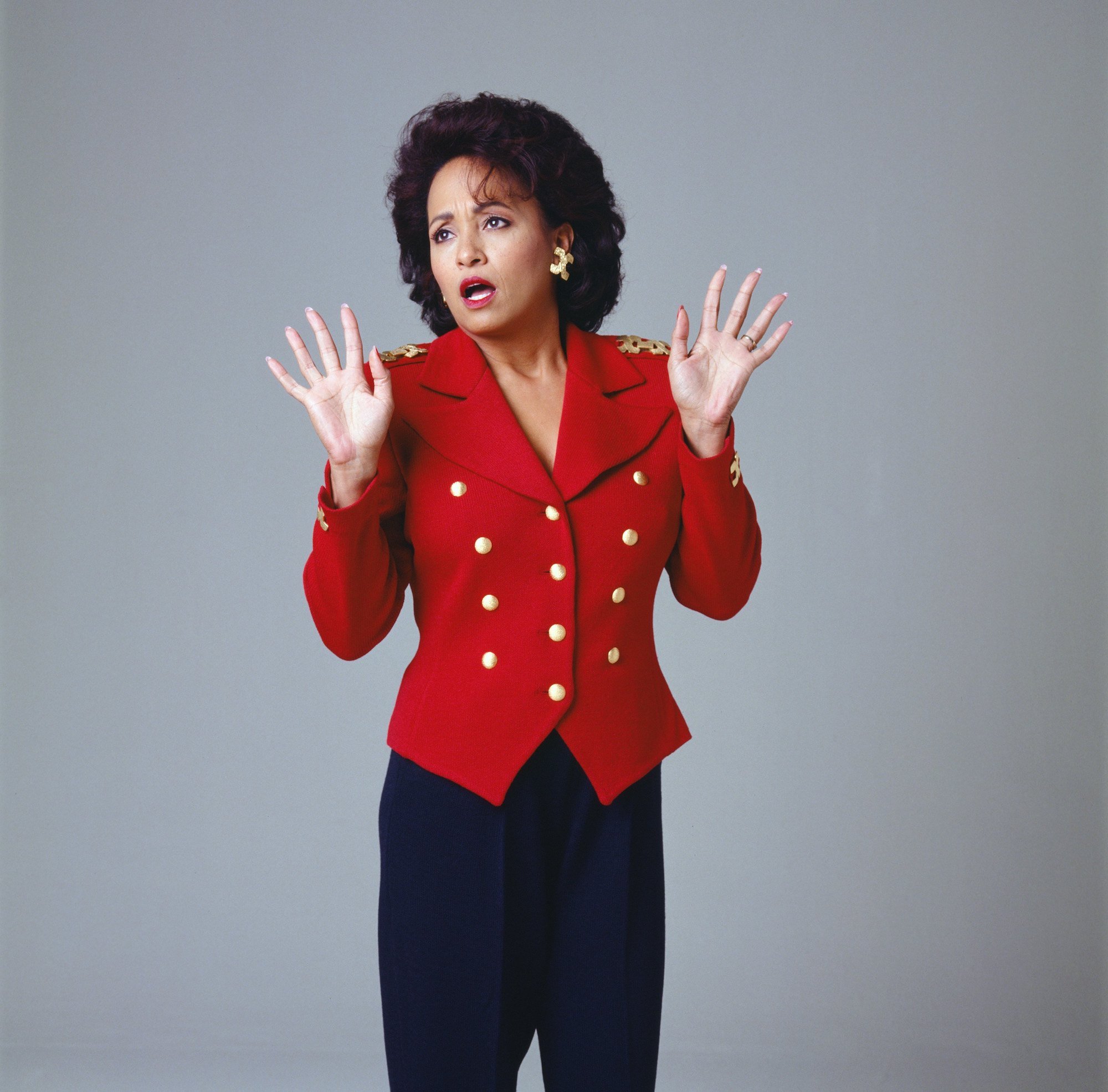 Daphne Reid as Vivian Banks in front of a gray background, holding up her hands