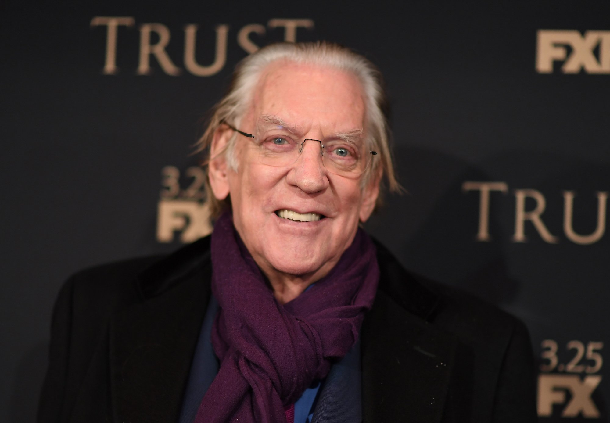 Donald Sutherland smiling in front of a black background