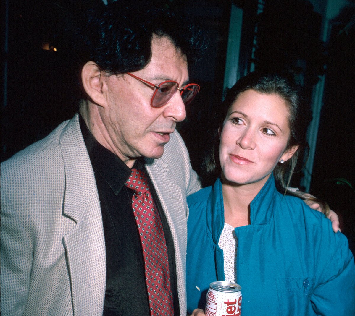 Eddie Fisher in a grey suit and daughter Carrie Fisher in a blue coat holding a Diet Coke | Time Life Pictures/DMI/The LIFE Picture Collection via Getty Images