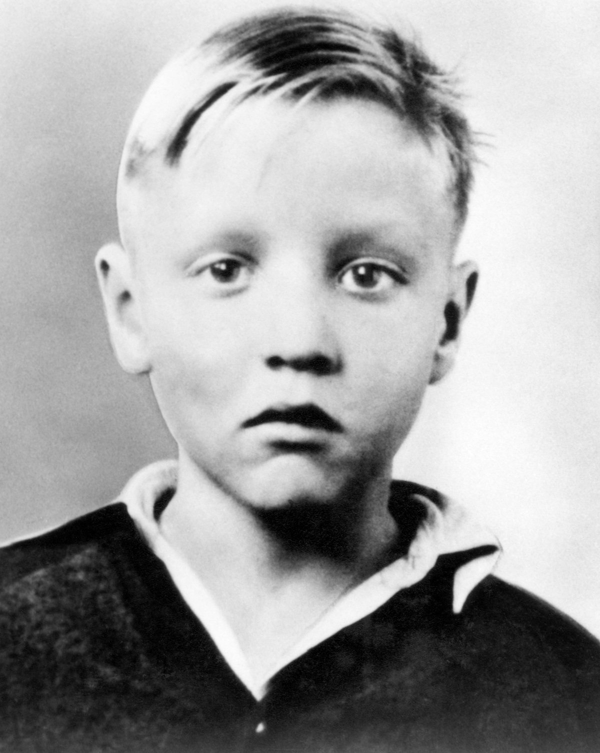 A headshot of a blonde Elvis Presley as a child in the early 1940s