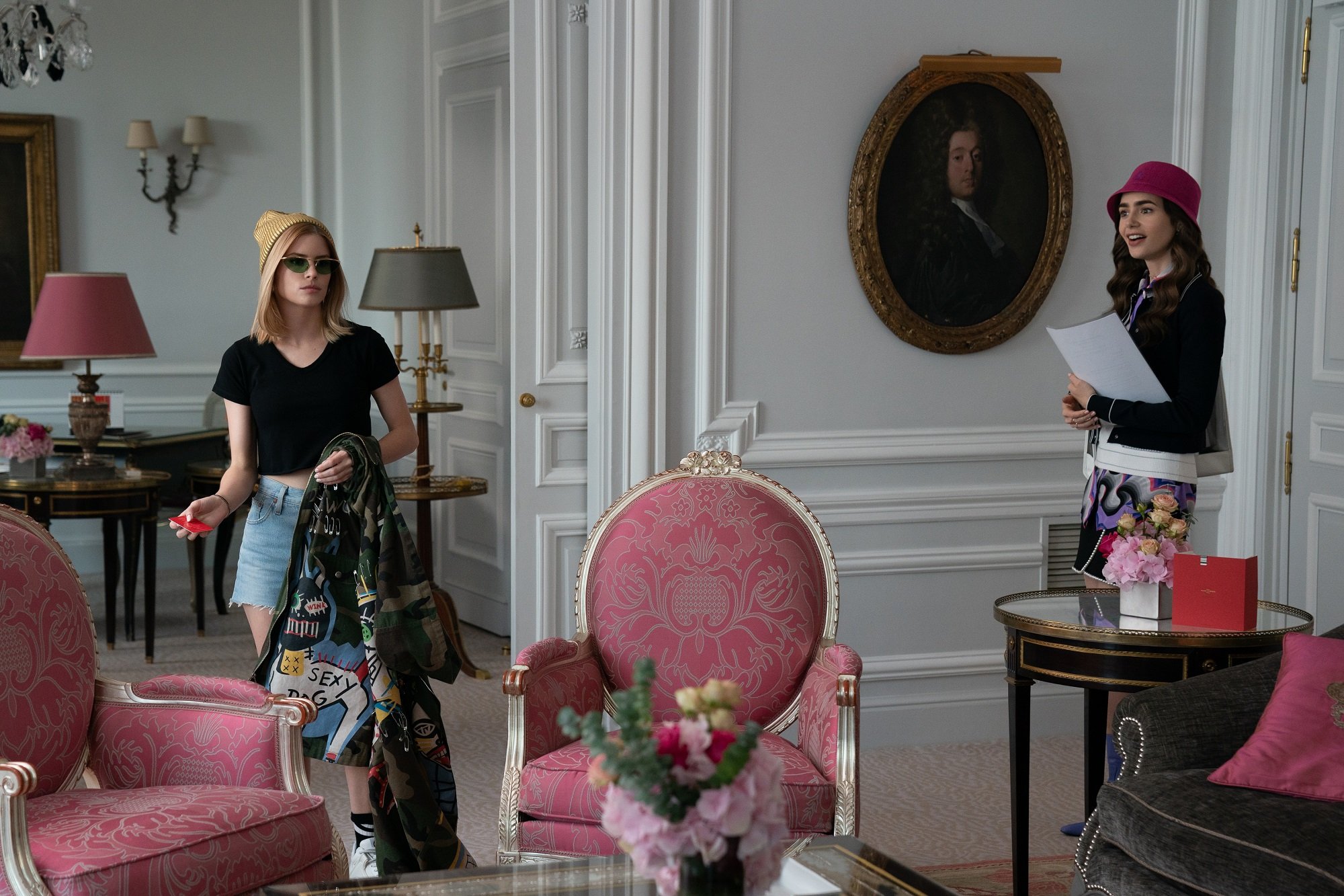 Emily In Paris: Carlson Young and Lily Collins in a hotel room