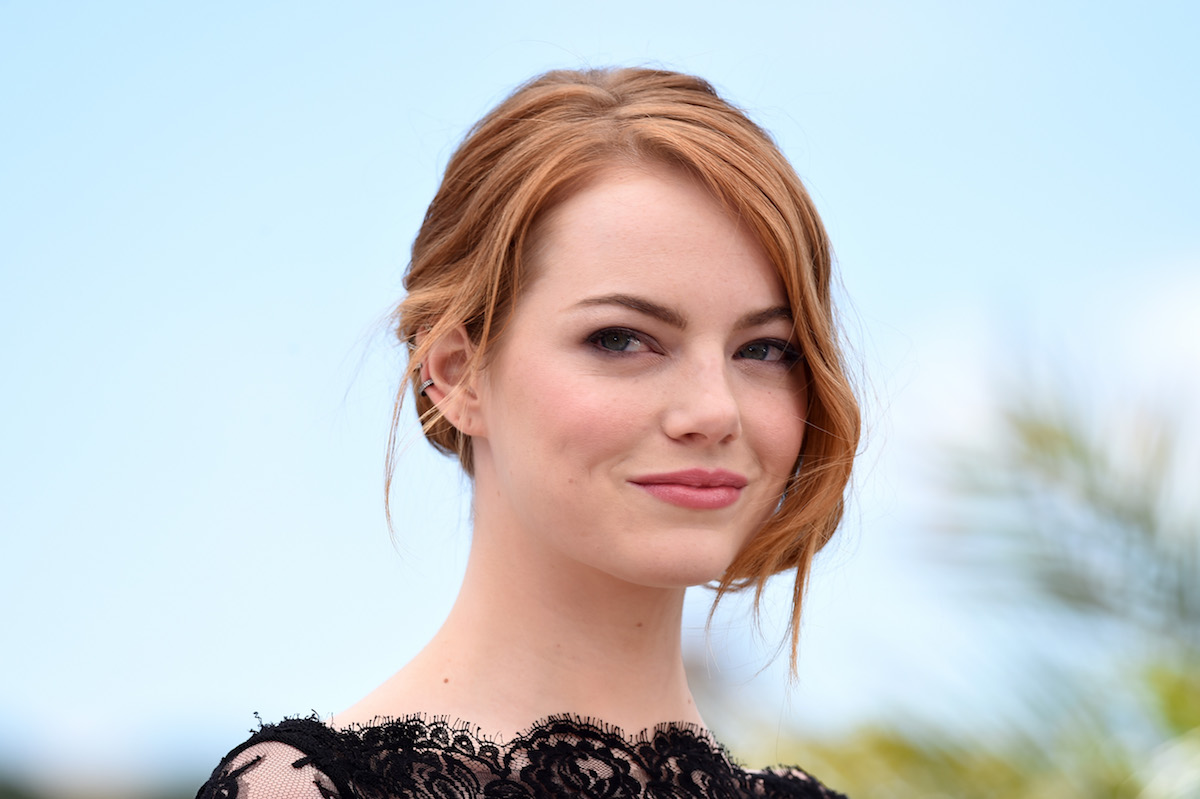 Emma Stone closeup with the actor staring at the camera with her hair tied up.