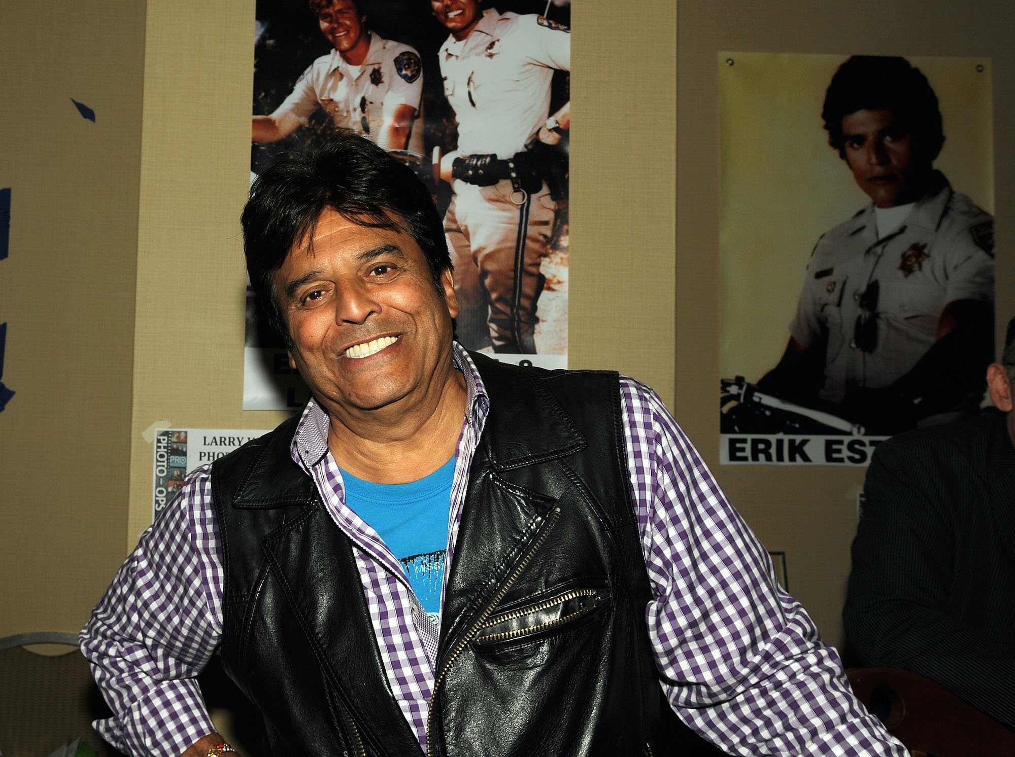 Erik Estrada smiling in front of posters of himself