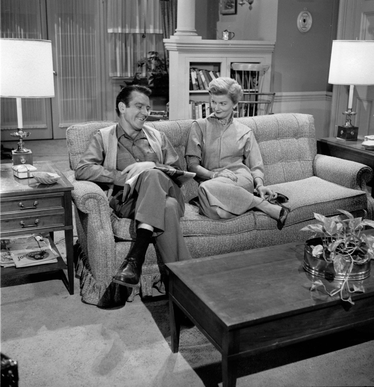 Hugh Beaumont and Barbara Billingsley sit on the couch in a scene from 'Leave It to Beaver'