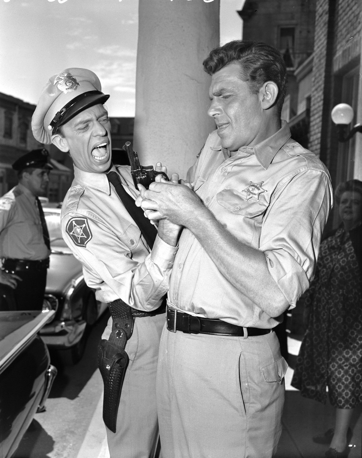 Don Knotts as Barney Fife and Andy Griffith as Sheriff Andy Taylor fumble over a gun in a scene from 'The Andy Griffith Show,' 1960