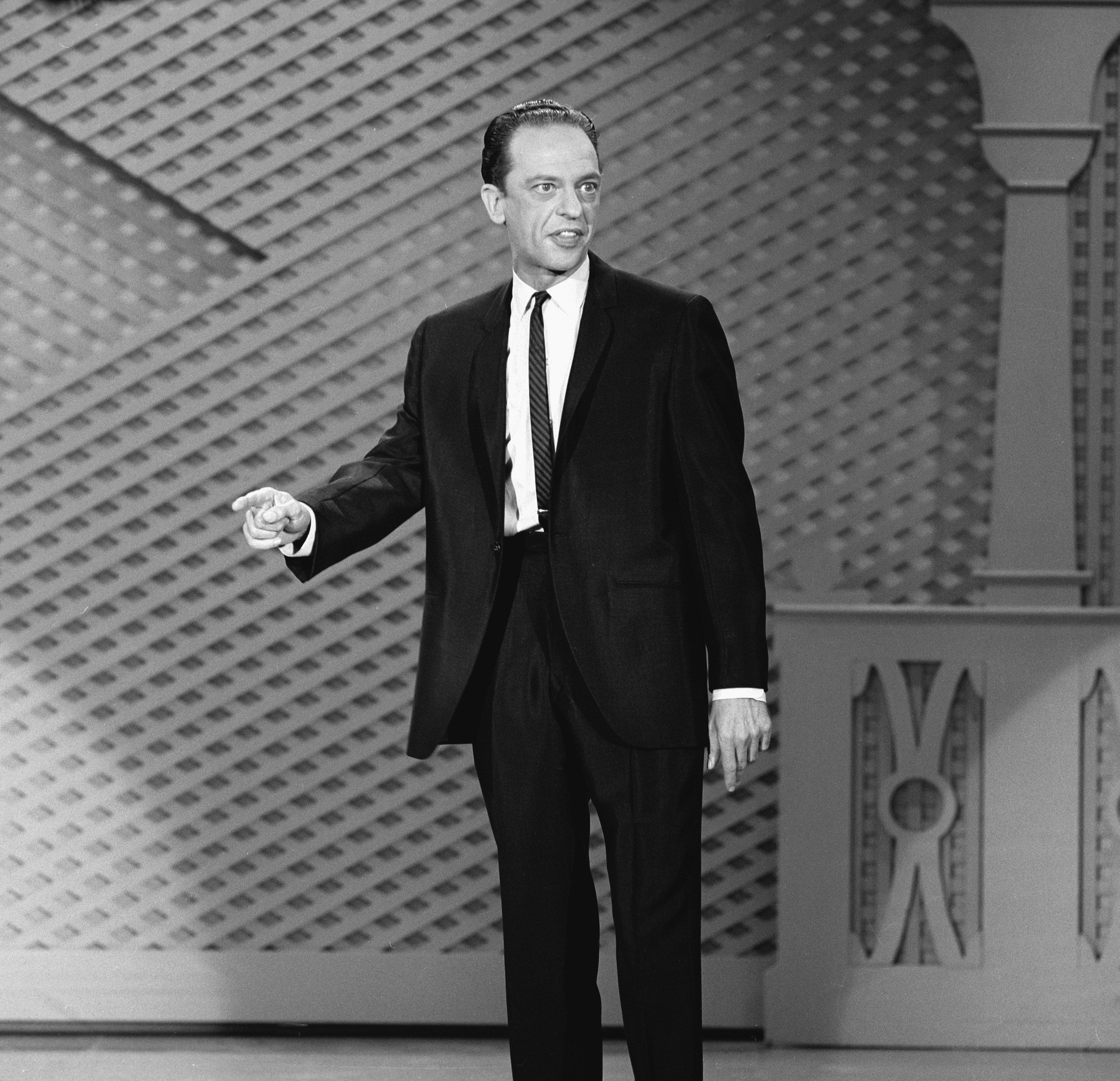 Television actor Don Knotts dressed in a suit and tie addressing an audience, 1965