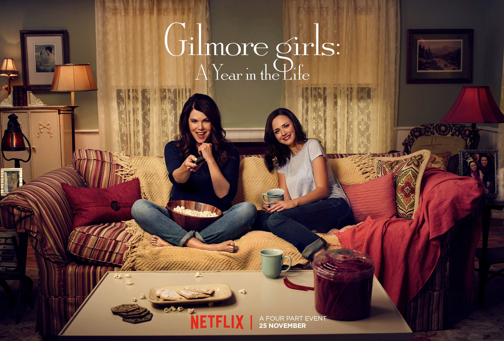 Lauren Graham and Alexis Bledel sit on a couch together in a promotional poster for 'Gilmore Girls: A Year in the Life'