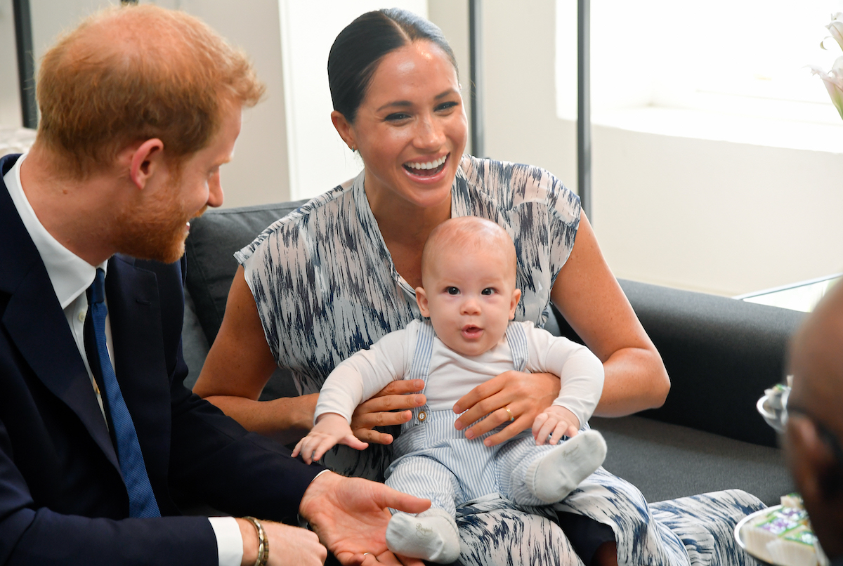 Prince Harry and Meghan Markle smile while son, Archie, sits on Meghan's lap