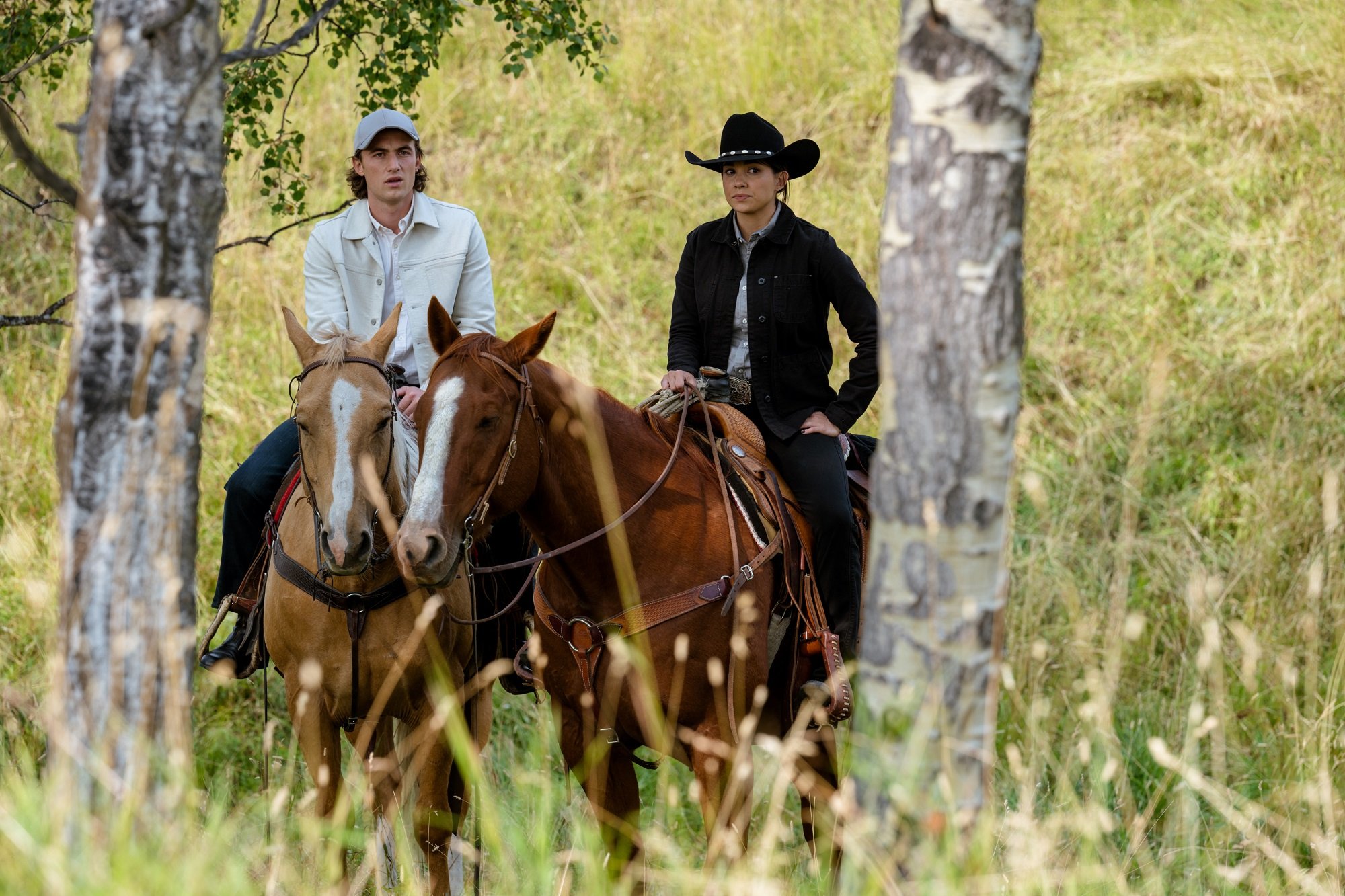 Jordan Burtchett as Quinn McGregor and Madison Cheeatow as Jade Virani ride horses in 'Heartland'