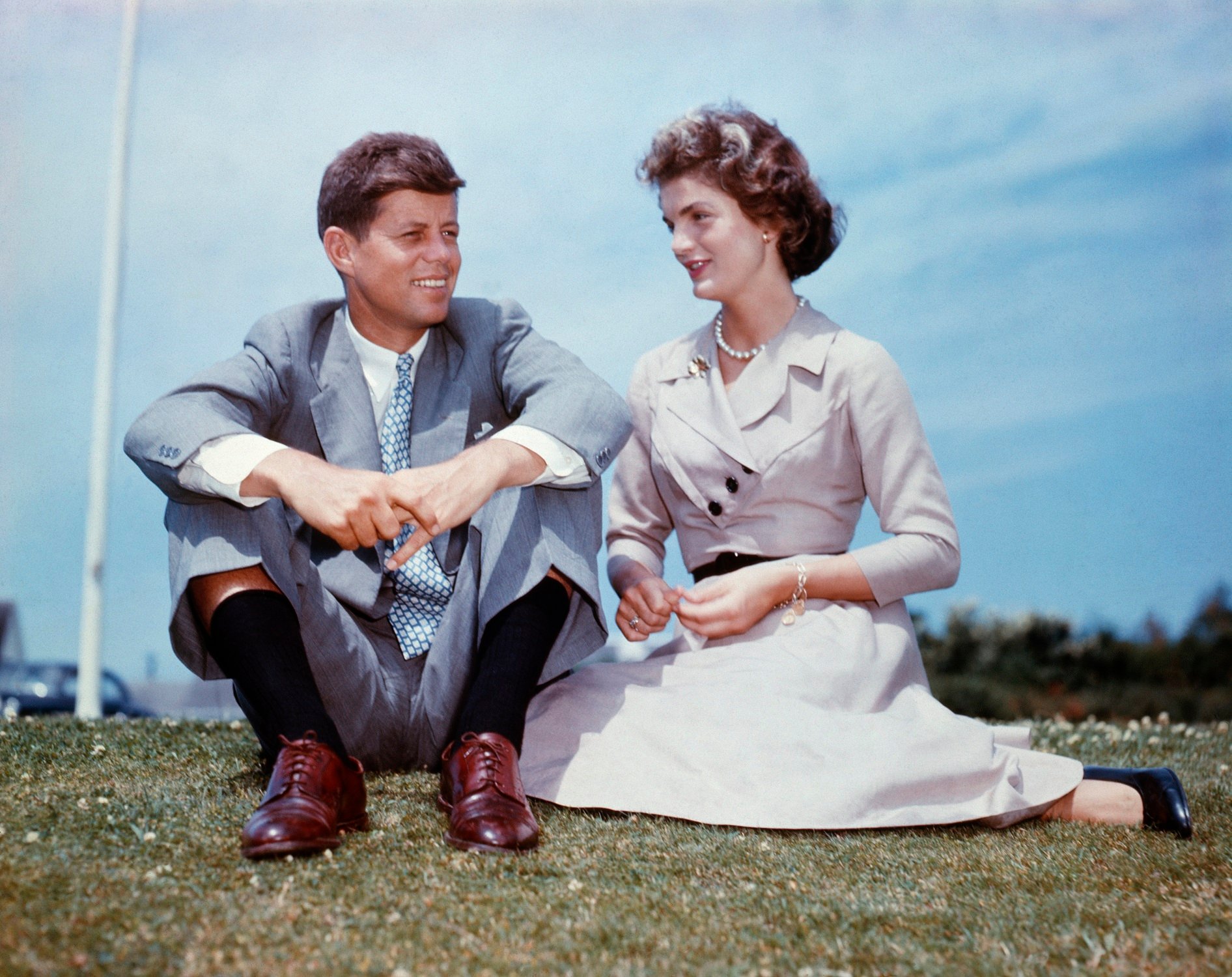 John F. Kennedy and Jacqueline Bouvier sit together in the sunshine at Kennedy's family home at Hyannis Port, Massachusetts, a few months before their wedding.